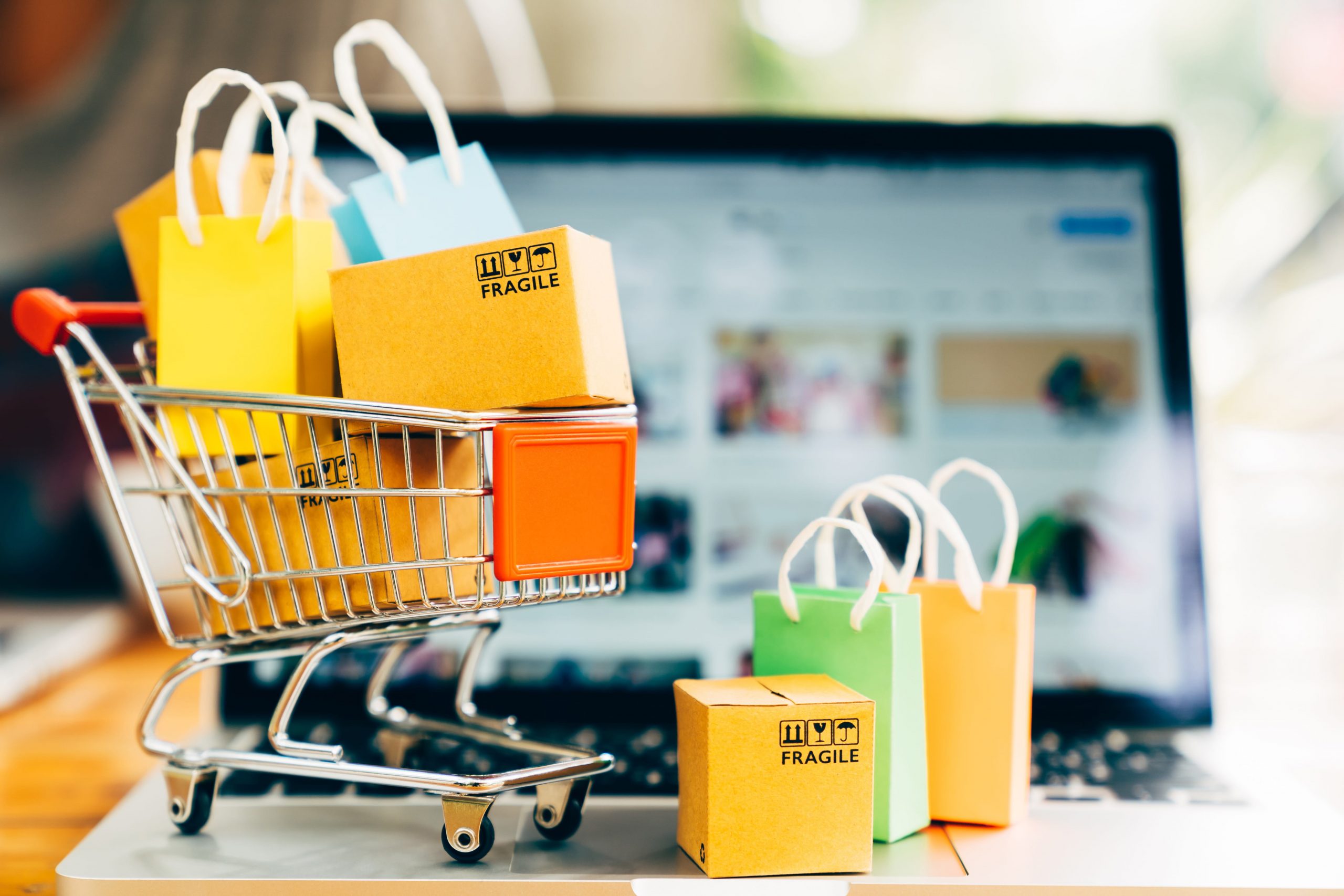 pacakges and shopping cart with laptop in background