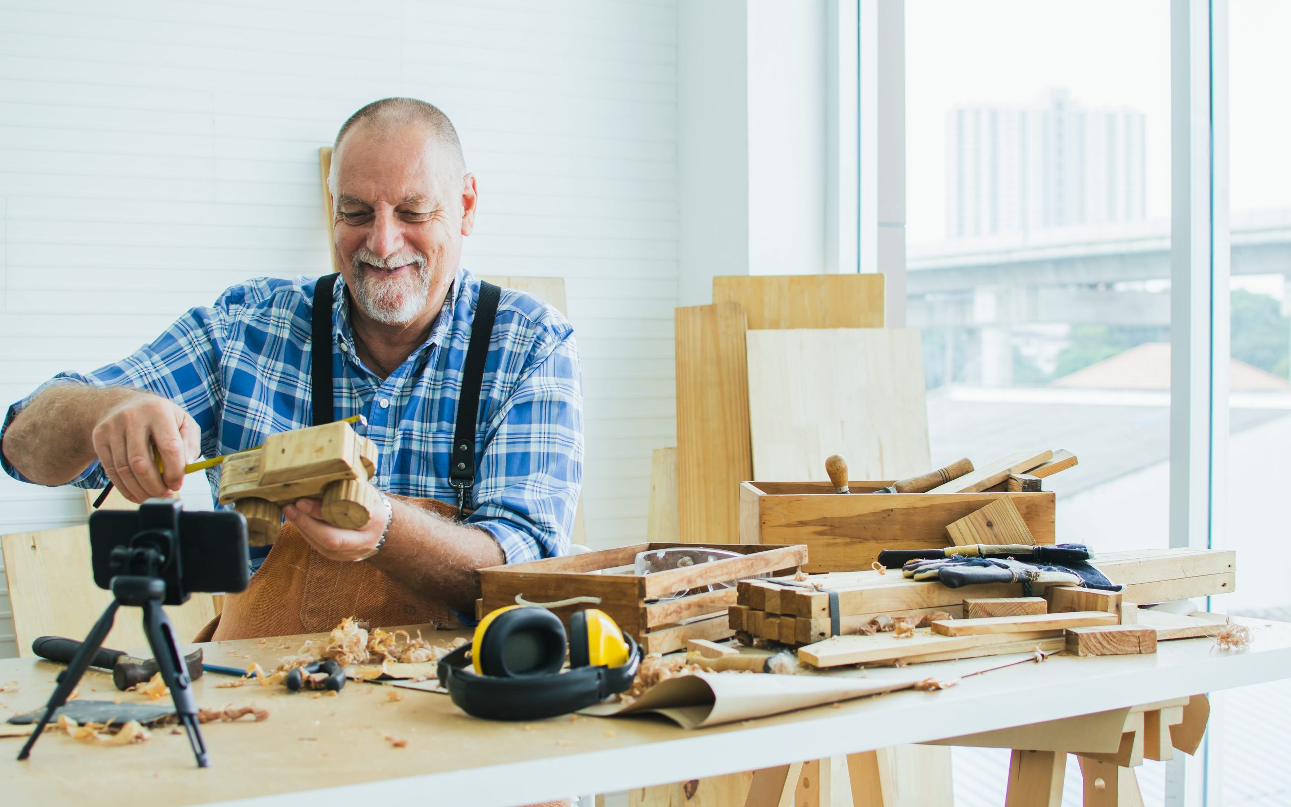 Man doing DIY wood project recording video