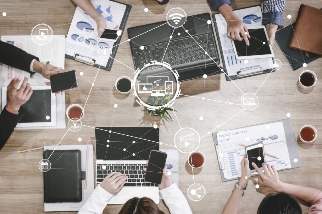 bird's eye view of people working around a table with different technological devices