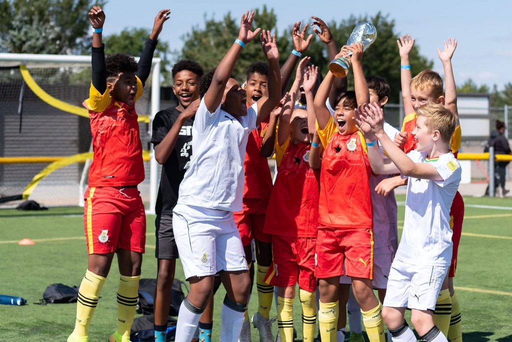 Kids celebrating the win with the cup in soccer